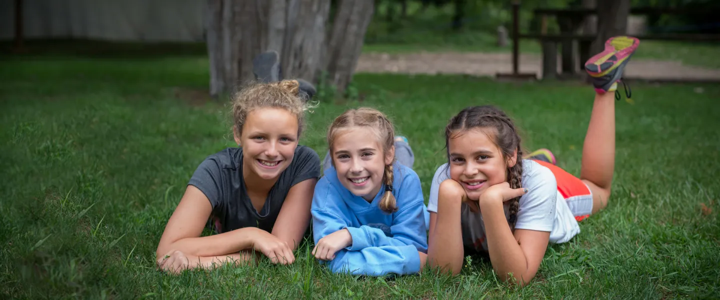 3 young women enjoying the grass.