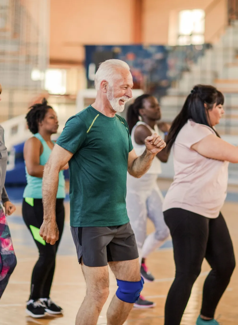 A diverse group of people participate in a fitness class at the Y.