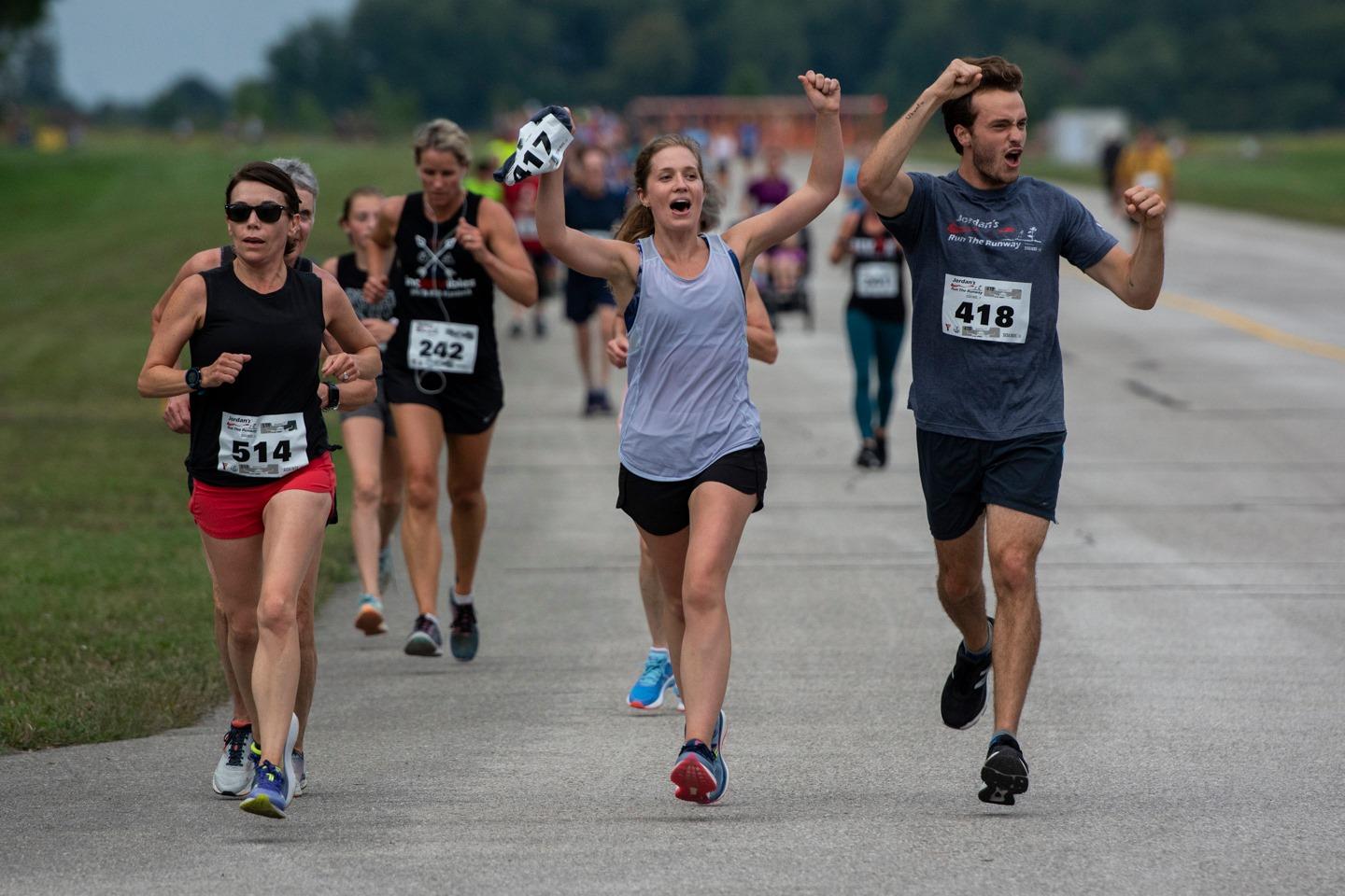Runners celebrate with hands in the air as they participate in Jordan's Run The Runway.