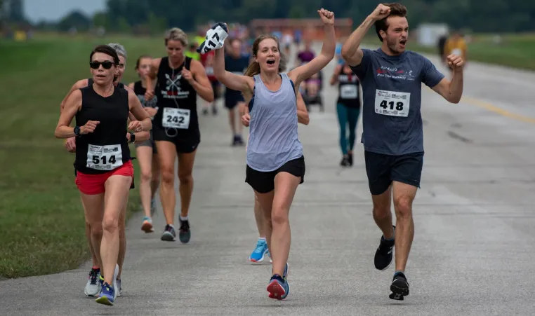 Runners celebrate with hands in the air as they participate in Jordan's Run The Runway.