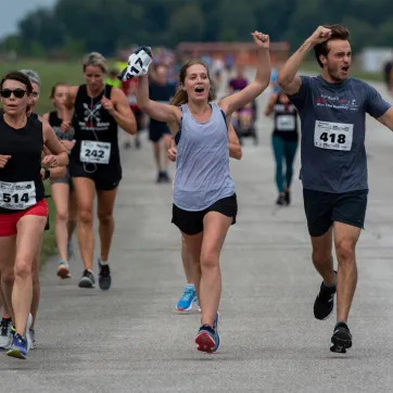 Runners celebrate with hands in the air as they participate in Jordan's Run The Runway.