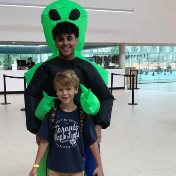 Daniil smiles and poses with a day camp counsellor in costume at the StarTech.com YMCA.