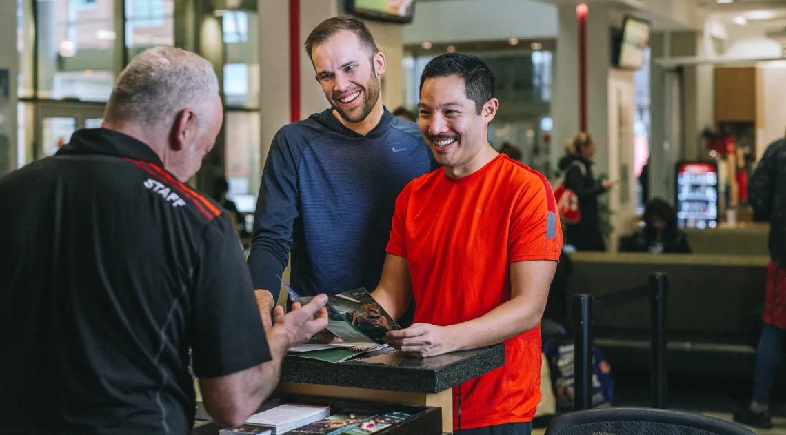 Staff helping YMCA members at the front desk