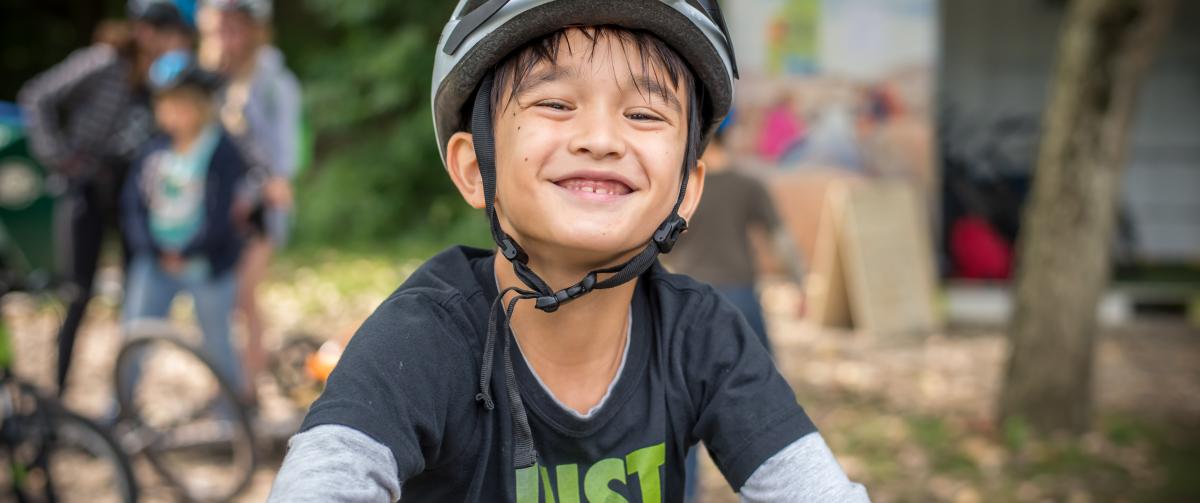 Smiling boy getting ready to ride his bike at Camp Henry