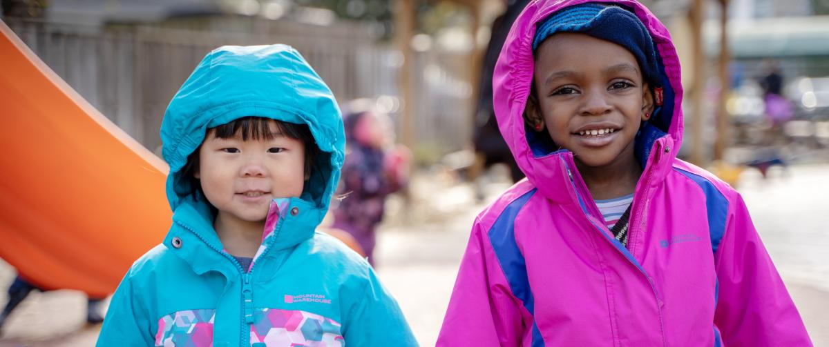 Two smiling girls playing outside