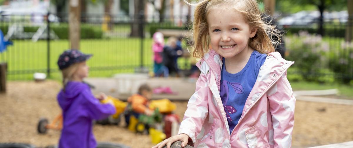 Smiling girl playing outside during after care