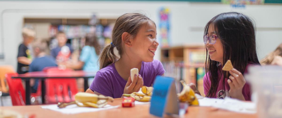 Two girls enjoying a snack while at after care