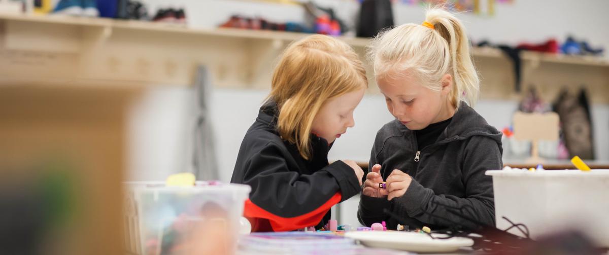 Two girls working together making a craft