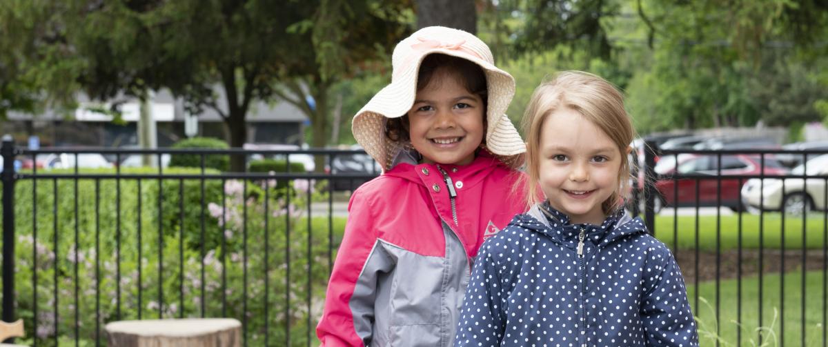 Two smiling girls playing outside